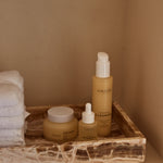 Anare Naturals Daily Essentials Bundle placed in the corner of a wall in an aesthetic bathroom with brown accents.