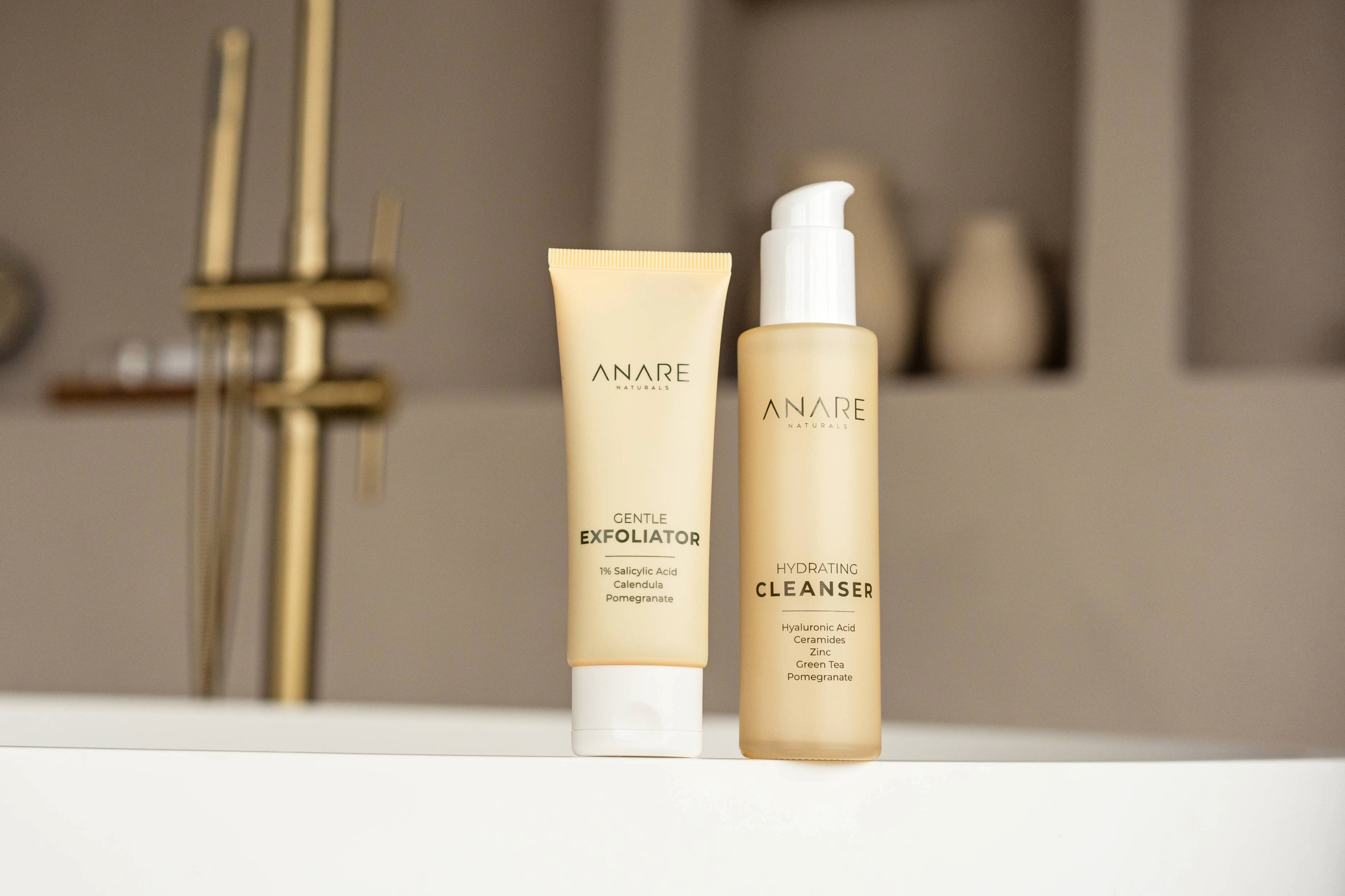 Deep Cleanse bundle with Hydrating Cleanser and Gentle Exfoliator placed on the side of a bathtub in a sand-colored bathroom, creating a calming spa-like feel.