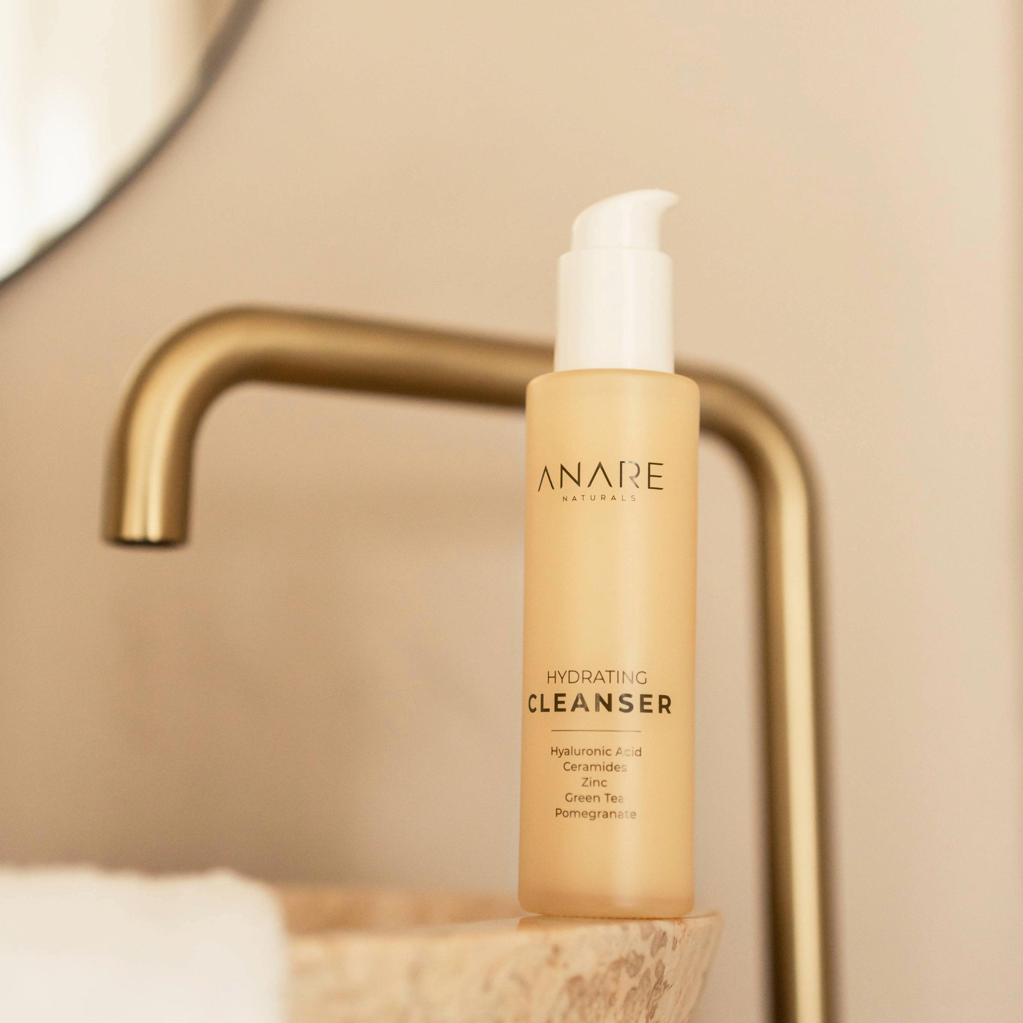 A sleek glass bottle of the Hydrating Cleanser resting on a bathroom sink, ready to refresh and cleanse your skin.