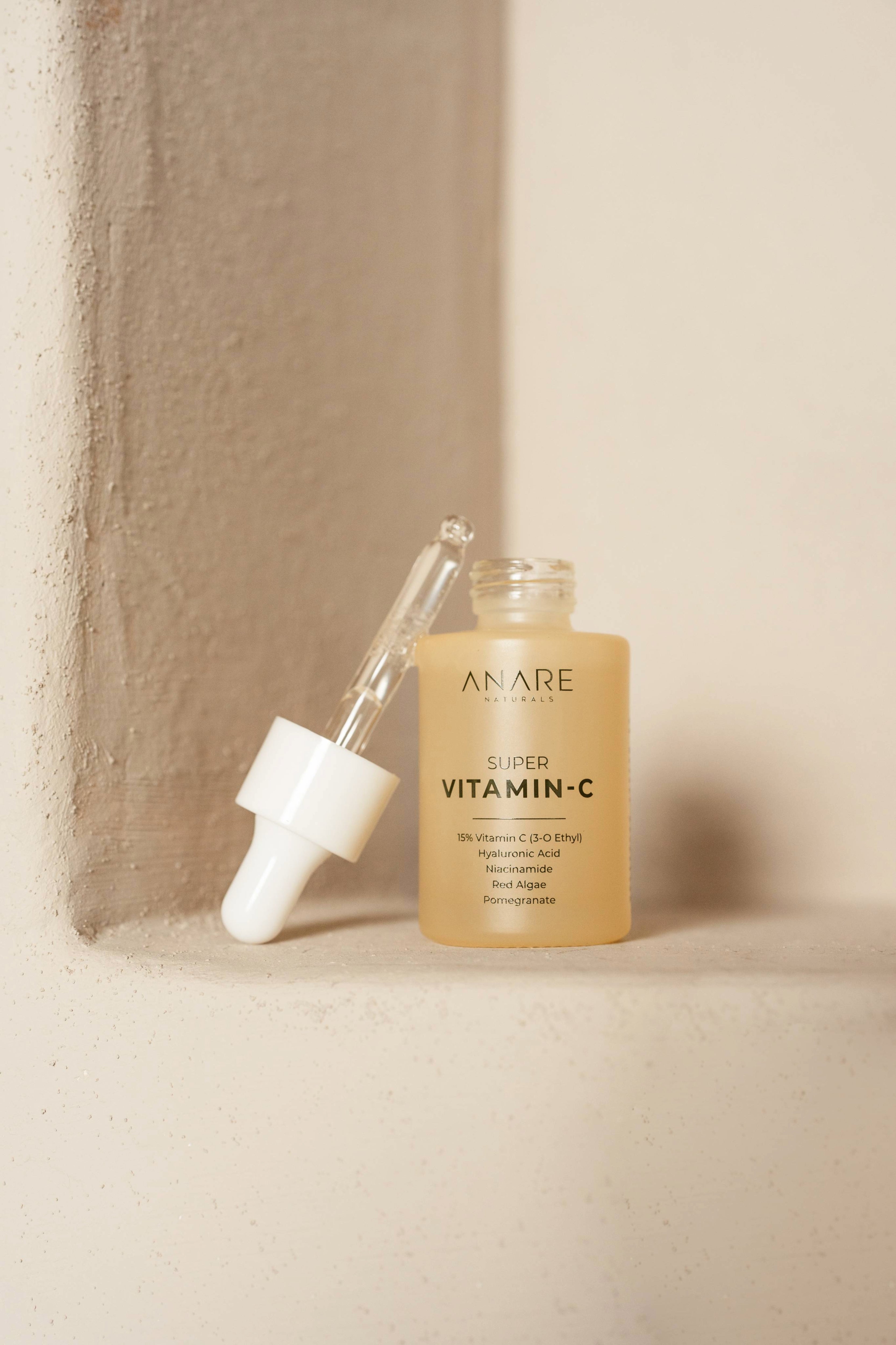 Anare Naturals Super Vitamin C Serum bottle placed in the corner of a brown aesthetic wall.